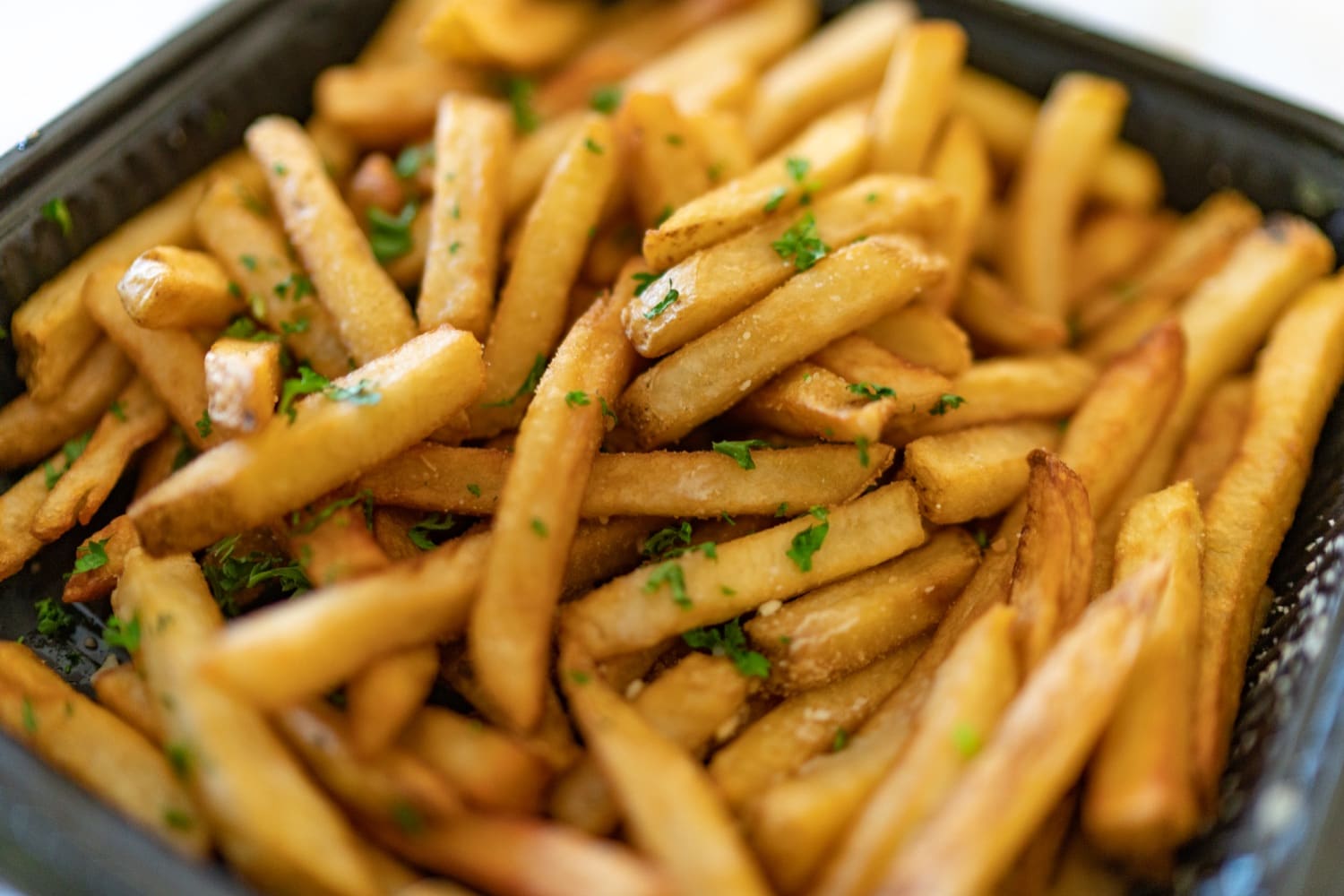 Frische Pommes mit Petersilie in der Ausgabeschale